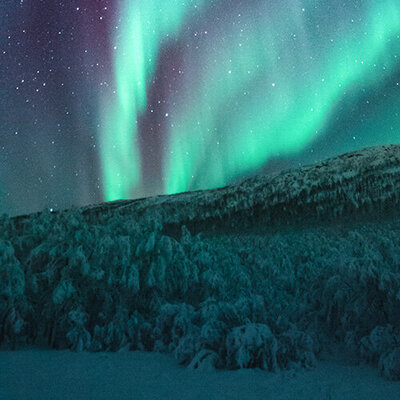 aurora borealis northern lights over a snowy mountain