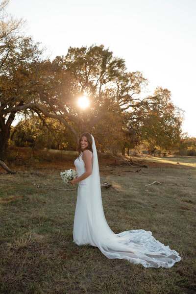 Bride posing by tree