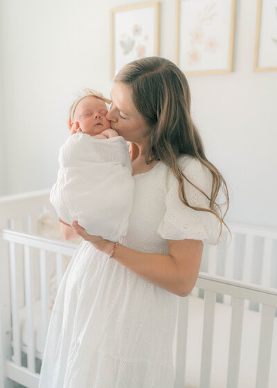 Newborn session in American Fork,  mom holding newborn in the nursery captured by a Utah newborn photographer 