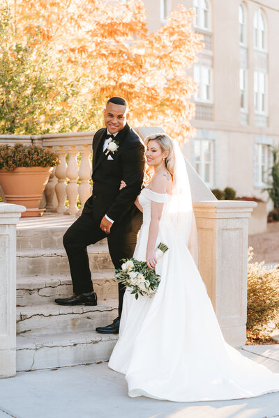 Groom holding Bride's hand walking up the stairs