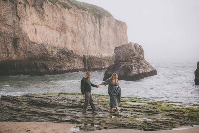 A couple holds hands during their adventure session in Davenport California.