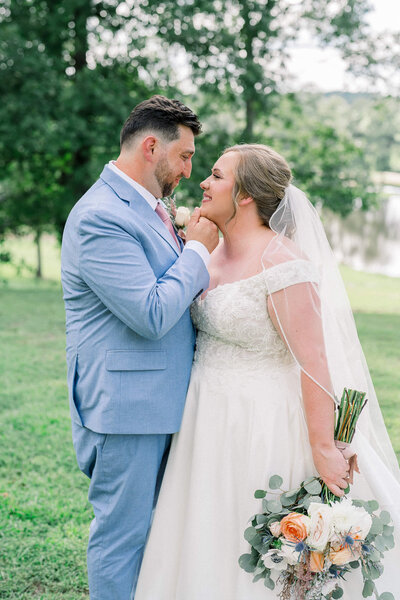 Newlyweds share an intimate moment surrounded by greenery. Jackson Ms Wedding Photographer creates magic.