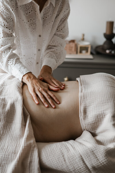 Handen die een rug masseren tijdens kraammassage