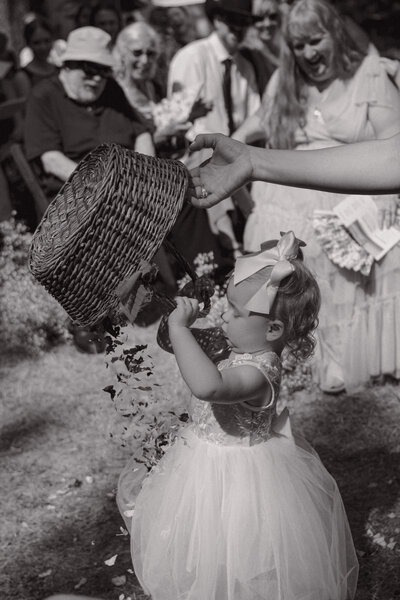 Flower girl looking at all the flowers in her basket 