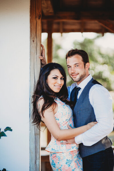 Couple smiling and posing together against a wooden post during a portrait session in Winter Garden, Florida.