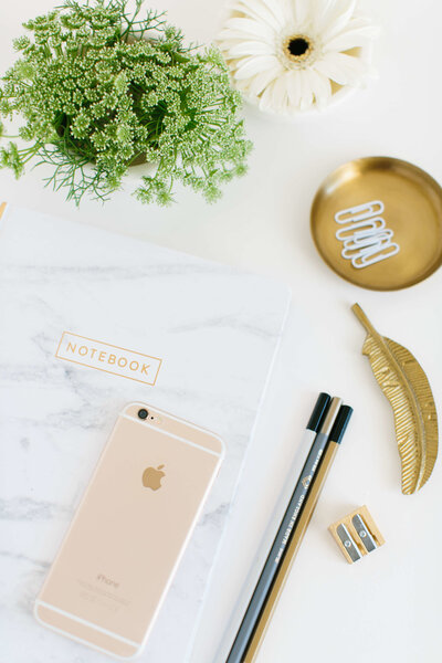 Modern desk flatlay in soft pinks, greens, white marble and gold.