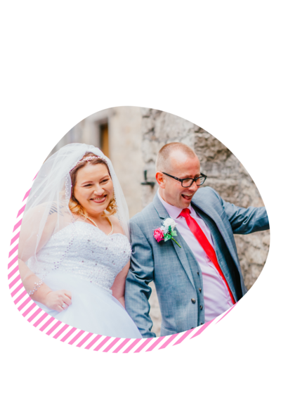 a bride and groom smiling and being silly as they walk down the aisle