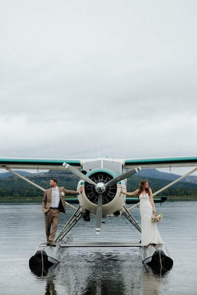 Newlyweds kissing in front of a dramatic Alaskan fjord.