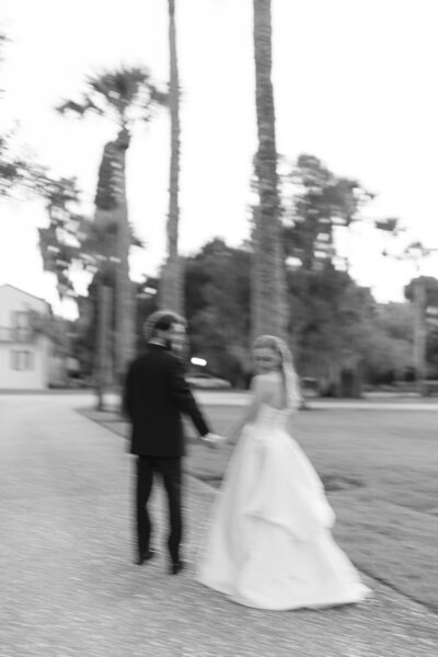 blurred black and white photo of wedding couple walking