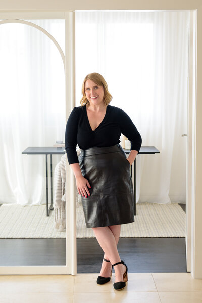 Kristen leaning on the study doors of the Sandringham pre-sale renovation