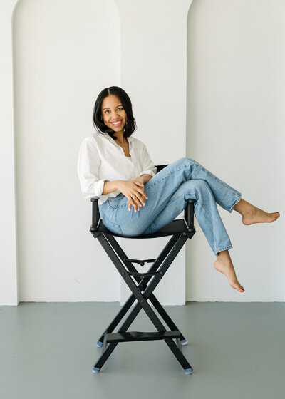 woman sitting on a black directors chair with her feet up