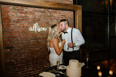 Bride and groom kissing after cutting cake
