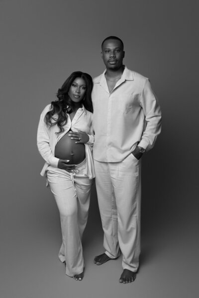 Professional maternity photography session in Austin featuring expectant couple in coordinated neutral outfits at Cedar Park studio

