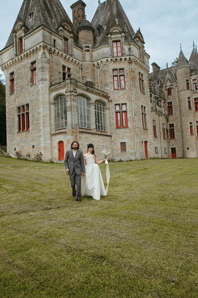 Newly weds wearing tan suit and white wedding dress run together down old san jan brick path