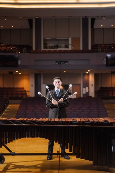 a high school music student posing with a Marimba