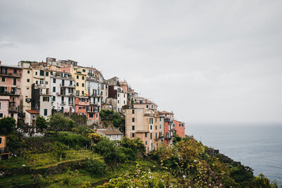 colourful italian homes tucked among the trees and clouds