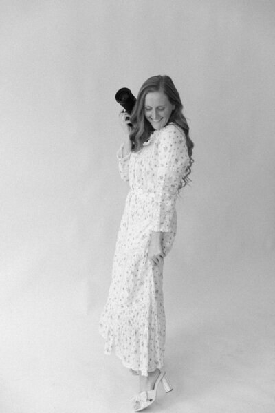 Lacey graham a luxury wedding photographer in Springfield Illinois poses while holding her camera