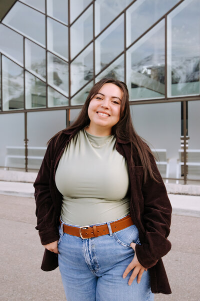 Event planner in cozy winter outfit and grey beanie smiling in snowy Banff forest – Rocky Mountain Wedding Collective