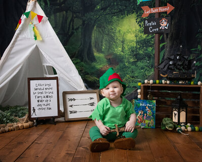 Baby dressed as Peter Pan poses with Peter Pan decor