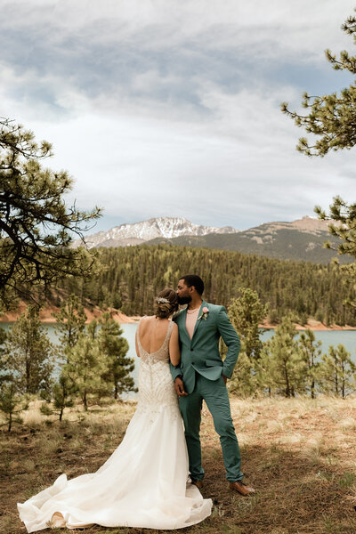 Bride and groom stand together for their bridal portraits in front of Pikes Peak in Colorado.