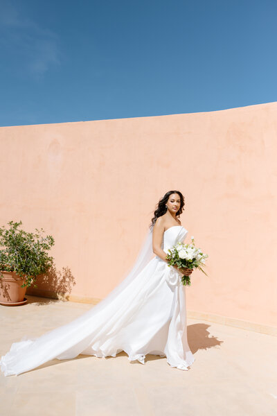 bride walking wearing dress holding bouquet in marrakech 