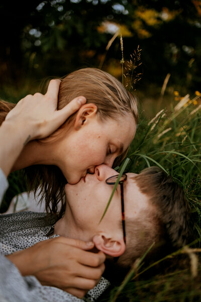 Couple kissing in the grass for engagement shoot in seattle