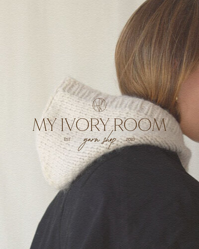 Side shot of woman wearing a knitted hood with logo on top