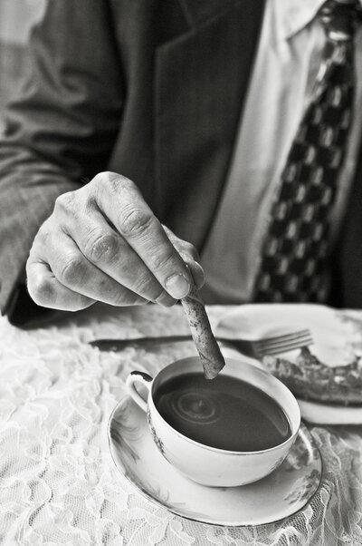 A person dipping biscotti into a coffee