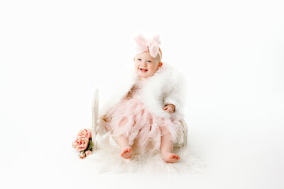 First birthday girl in pink and white with flowers in Fresno, CA portrait studio One Good Shot Photography