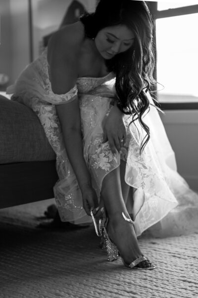 A bride buckles her high heel, getting ready for her wedding.