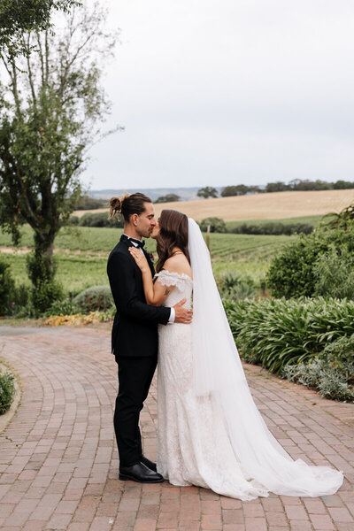 Julia and Addy sharing a kiss during portrait session after their wedding ceremony