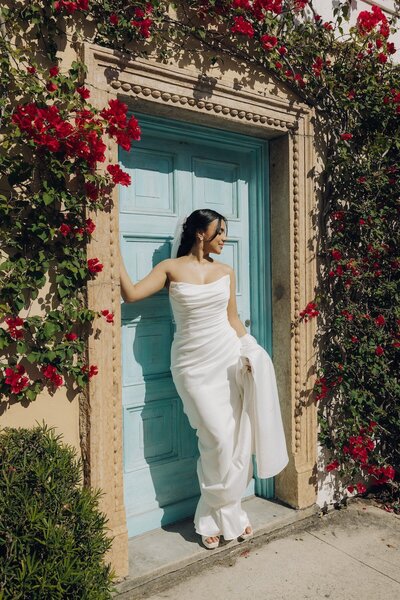 bride poses next to flowers after wedding