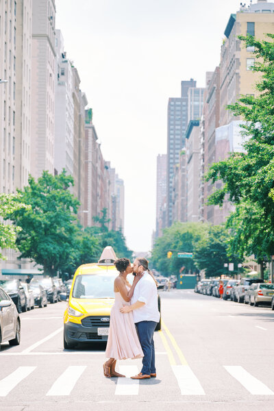 Couple kiss in the middle of the street in NYC during their engagement session. Photo taken by NYC Engagement Photographer Corey Lamar Photography