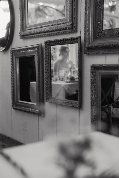The reflection of a wedding guest in a mirror at Farm Road Estate in West Dover Vermont