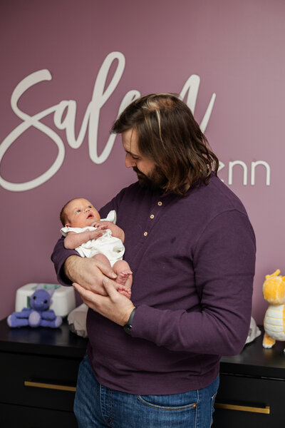dad holding newborn in nursery in berks county pa