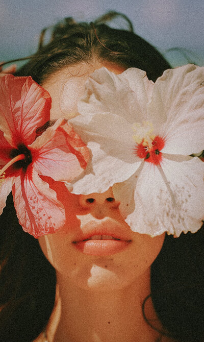 Woman with flowers in front of her face representing feminine energy