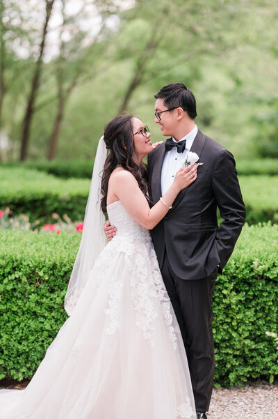 A newlywed couple poses for portraits after their Catholic wedding at St. Luke Catholic Church in Virginia Beach, captured during their wedding reception at the Founders Inn and Spa by Nathan Sottung Photography.