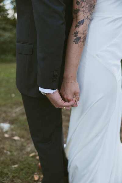 A close-up of a couple holding hands during sunset at Iron Horse Park in Overland Park, KS, capturing a tender moment of love and connection with the warm glow of the setting sun.