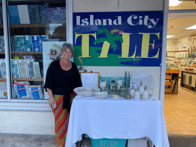 Jill stands beside a table of her pottery on display at Island City Tile in Key West, FL during a monthly art walk featuring more than 25 local businesses and artists in the White Street Gallery District