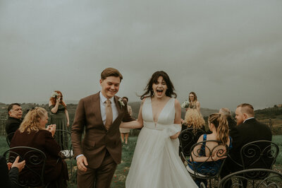 Couple walking down the aisle at Tuscany elopement in Italy, captured on cinematic Super 8 film & moody editorial style