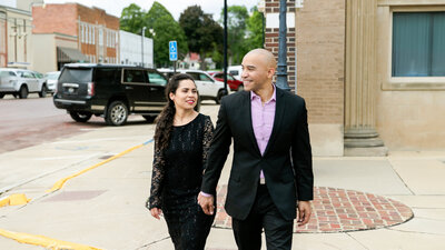 wedding videographer ariel rosses the street with his fiancee in sibley iowa