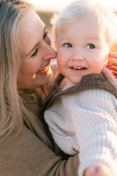 Gezinsfotograaf Leiden zet moeder en kind knuffelend en lachend op de foto