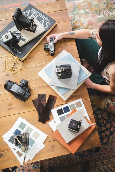 One of the top photographers in baltimore md holding camera and albums