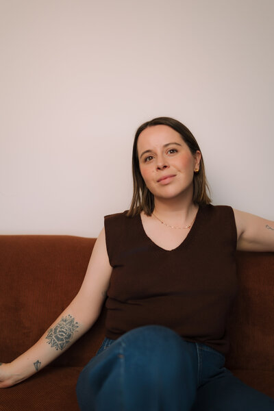Liv Rollings sitting on rust colored couch