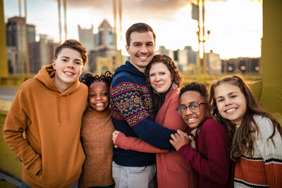 A portrait of a guy wearing a green sweater standing near the Ohio river in senior photos Pittsburgh Pennsylvania session.