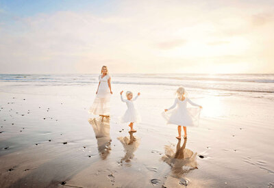 A mom and her two girls enjoying the waves at Ponto Beach during their Carlsbad photography session