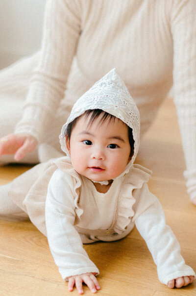 Seven month old baby girl dressed in neutrals for a studio photography session in Amsterdam West.