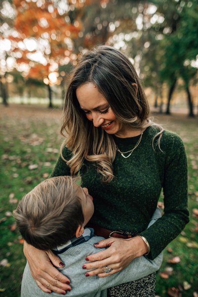 New born photoshoot with grandma kissing baby on the head.