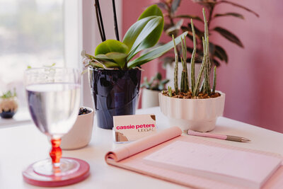 Plants and a business card on the desk of Cassie Peters, a cannabis law attorney in Eugene, Oregon. 
