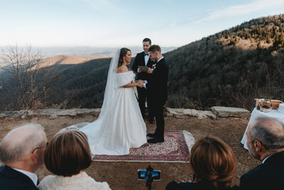 bride and groom holding each other in the mountains